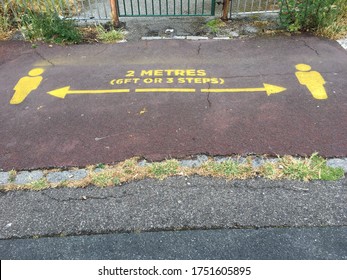 Two Metres Sign On Pavement At Entrance To A Public Park As A Reminder For New Normal Social Distancing 