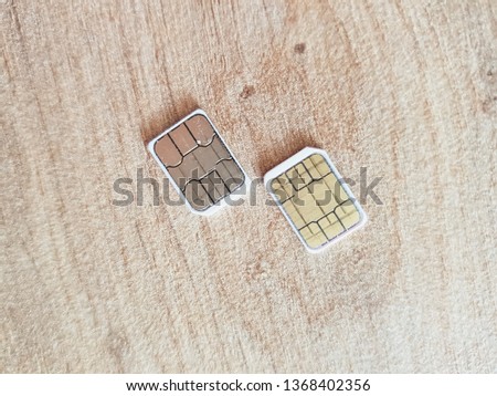 two micro sim cards on a wooden surface background