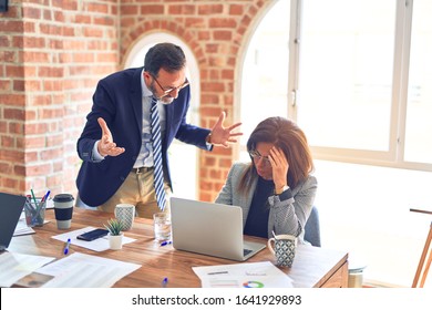 Two Middle Age Business Workers Working Together. Man Bullying Woman At The Office