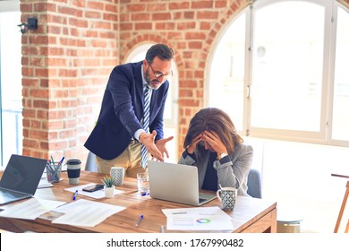 Two Middle Age Business Workers Working Together. Man Bullying Woman At The Office