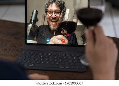 Two middle aged friends toasting with red wine in video calling 