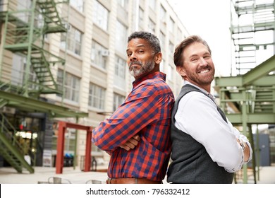 Two Middle Aged Men Stand Back To Back Outside Workplace