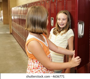 Two Middle School Students Chatting At Their Lockers.