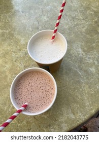 Two Milkshakes With Straws On The Table