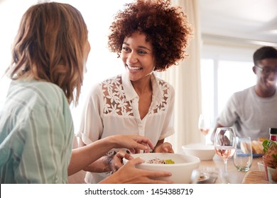 Two Millennial Girlfriends Talking At The Table During Lunch With Friends, Close Up