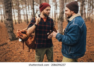 Two Millennial Man Hiking And Drinking Beer In A Pine Forest, Laughing And Having Fun.