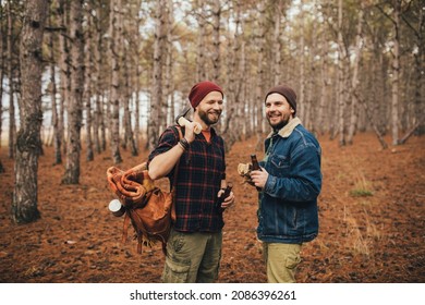 Two Millennial Man Hiking And Drinking Beer In A Pine Forest, Laughing And Having Fun.