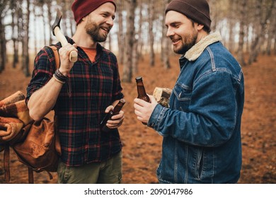 Two Millennial Man Hiking And Drinking Beer In A Pine Forest, Laughing And Having Fun.