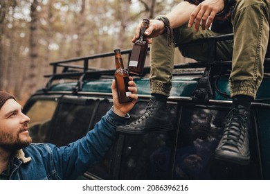 Two millennial man hiking in a pine forest, drinking beer and having fun. - Powered by Shutterstock