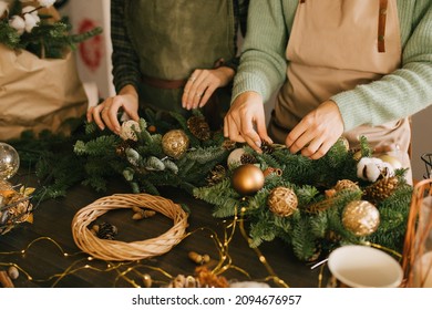 Two millennial women making Christmas wreath using fresh pine branches and festive decorations. Small business - Shutterstock ID 2094676957