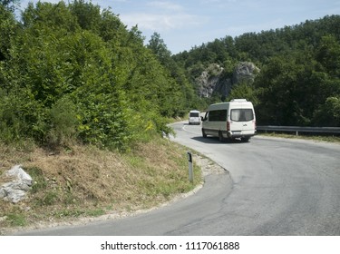 Two Mini Buses Driving Up The Hill