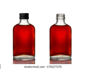 Two mini glass bottles with brown beverage, one with a black cap and another one open.