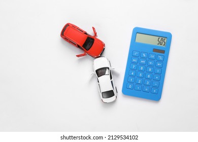 Two Mini Toy Car Crash With Calculator On White Background, Incident, Car Traffic Accident. Top View