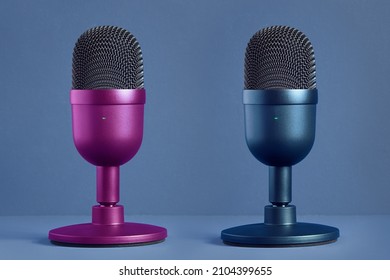 Two minimalist, modern and colorful microphones for streaming, gaming, and podcasting face to face on a pastel color background with texture. Technology and entertainment. Product and design. - Powered by Shutterstock