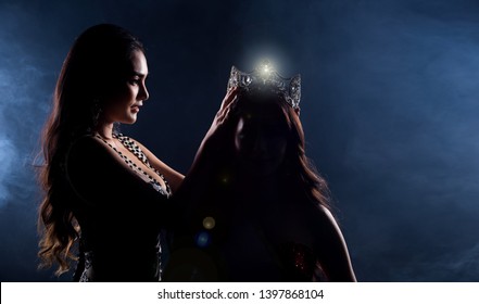 Two Miss Asian Women Pageant Beauty Contest in Evening Ball Gown dress wearing silver diamond crown on head sash, waiting final announcement moment, dark smoke background low key exposure silhouette - Shutterstock ID 1397868104