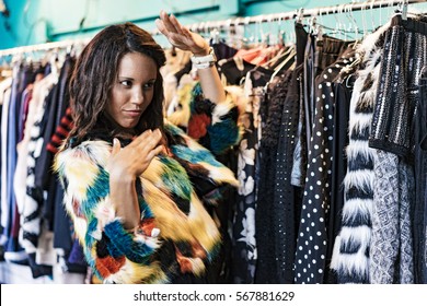 two mixed race female friends buying clothes in a store and having fun