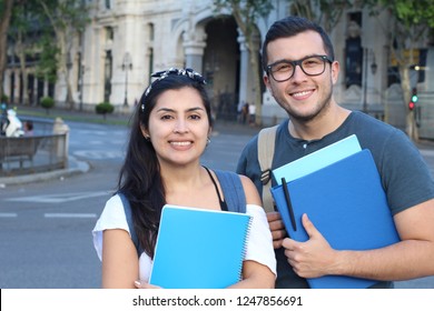 Two mixed race students smiling outdoors - Shutterstock ID 1247856691