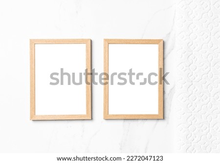 Two mockup wooden frames on white table with white towel.