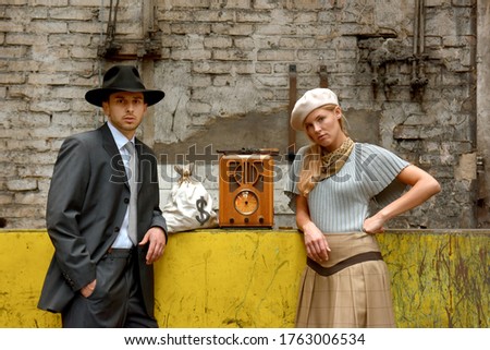 Two models get dressed up in 1930's style vintage 
clothing and act the part of the gangster duo 
Bonnie and Clyde. They are seen in the ruins of an 
old demolished factory.