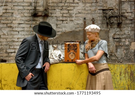 Two models get dressed up in 1930's style vintage 
clothing and act the part of the gangster duo 
Bonnie and Clyde. They are seen in the ruins of an 
old abandoned factory.