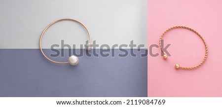 Two modern bracelets on geometric paper pastel colors background with copy space