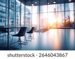 Two modern chairs sit at a table in a contemporary office space, bathed in the warm glow of a setting sun visible through expansive windows overlooking a cit...