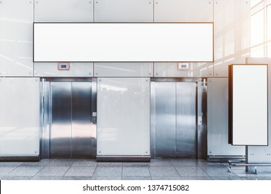 Two modern elevators in an airport terminal or a shopping mall or a railway station depot with two blank mockups: placeholder above and on the right, for your advertising or information text message