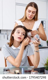 Two modern girls friends talking and applying make up in kitchen - Shutterstock ID 1795407298