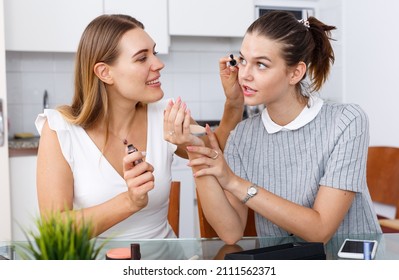 Two modern girls friends talking and applying make up in kitchen - Shutterstock ID 2111562371