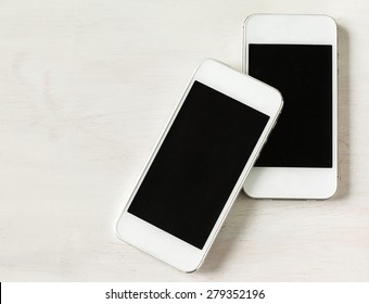 Two Modern Phones On Wooden Background