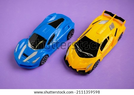 Two modern toy sports cars on purple background.