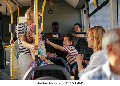 Two moms with their son and daughter in public transportation - Powered by Shutterstock