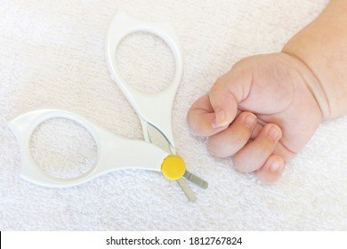 Two month old baby's hands and baby nail clippers