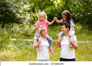 Two Mothers And Two Small Daughters In The Park