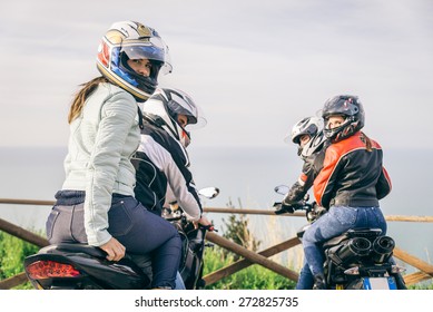 Two motorbikes driving in the nature - Friends driving racing motorcycles with their girlfriends - Group of bikers stop in a panoramic view point and look at suggestive sunset
