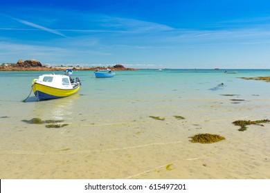 Two motorboats anchored at the seashore above yellow sand, copy space, background texture, Channel Islands, Jersey, near Le Hocq Tower