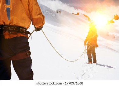 Two Mountaineers Hiking In Mountains Holding Ropes