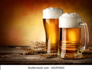 Two Mugs Of Beer And Wheat On A Wooden Table