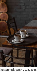 Two Mugs Of Coffee Stands On A Tray In A Restaurant.  Dark Colors, Loft Style Interior.  No People