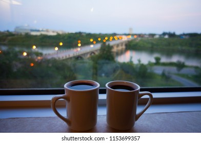 Two Mugs Full Of Coffee Sitting On A Hotel Window Ledge With A Great Bridge And Water View In The Background