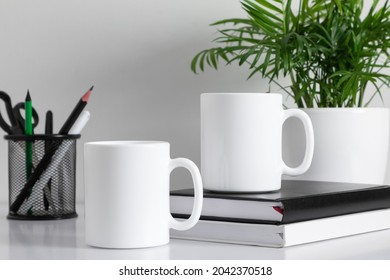 Two Mugs Mockup With Accessories On White Table. Front View