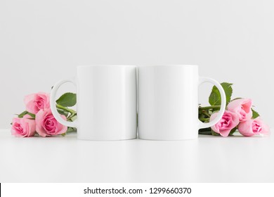 Two Mugs Mockup With Pink Roses On A White Table.