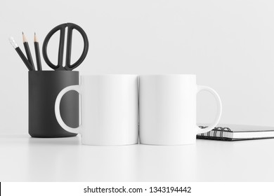 Two Mugs Mockup With Workspace Accessories On A White Table.