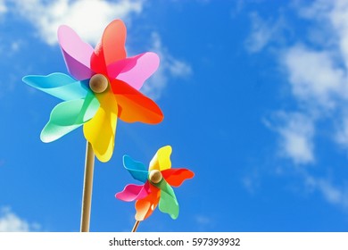 Two Multicolored Pinwheels Against Blue Sky 