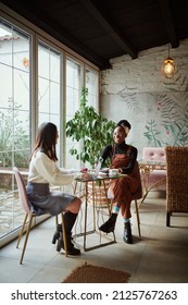 Two multicultural female students sitting in a cafe and studying for an exam. The lifestyle of a student. - Shutterstock ID 2125767263