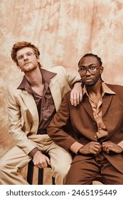 Two multicultural men with elegant style sitting together.
