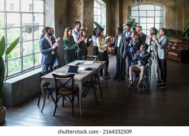 Two Multi-ethnic Business Women Sign An Agreement With A Handshake While Colleagues Clap Together Happy In Office Meeting Room - Concept Of People, Agreement, Promotion, Signing A Contract