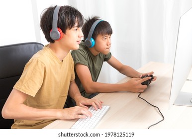 Two Multiethnic Teenage Boys Playing Computer Games At Home.