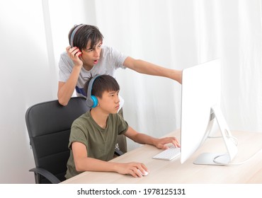 Two Multiethnic Teenage Boys Playing Computer Games At Home.