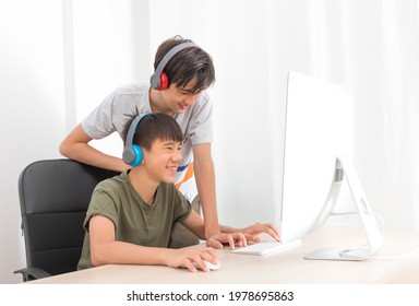 Two Multiethnic Teenage Boys Playing Computer Games At Home.